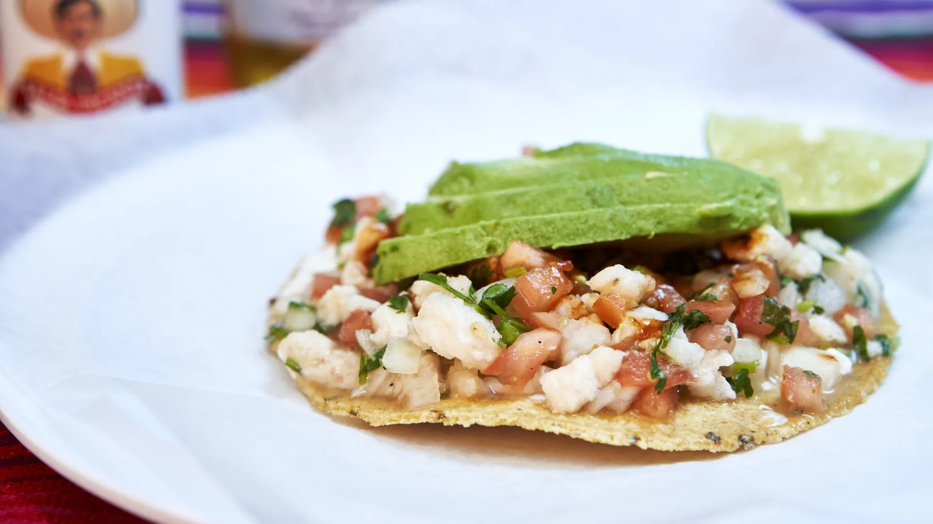 Fish ceviche tostada with avocado and lime.