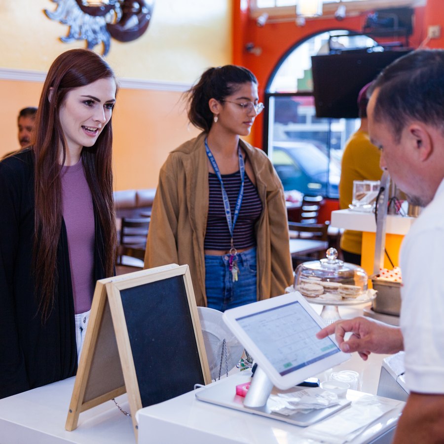 Customers ordering at the counter with a staff member.
