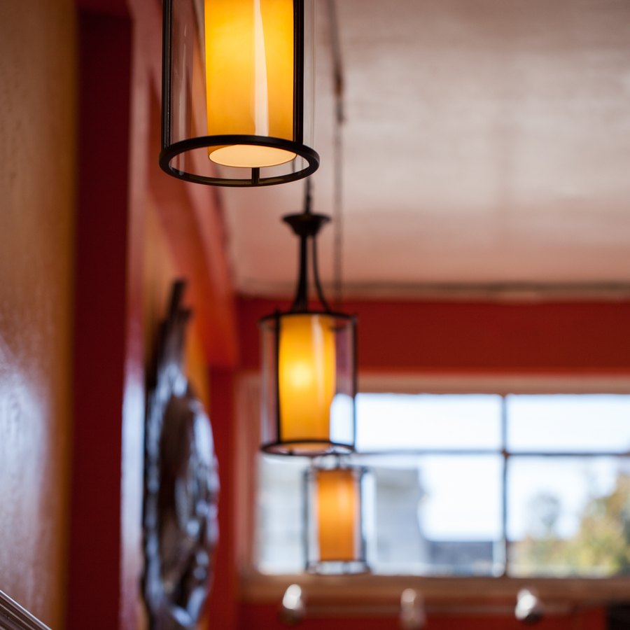 Warm pendant lights glowing inside the dining room.